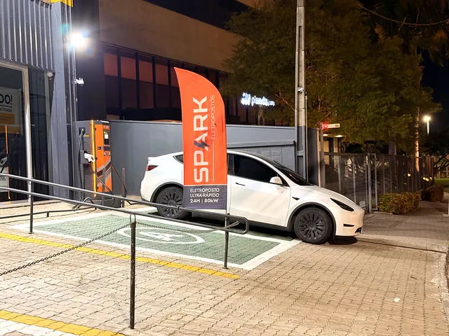 Eletroposto Spark iluminado à noite em Itu com carro elétrico carregando